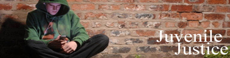 child sitting along a brick wall